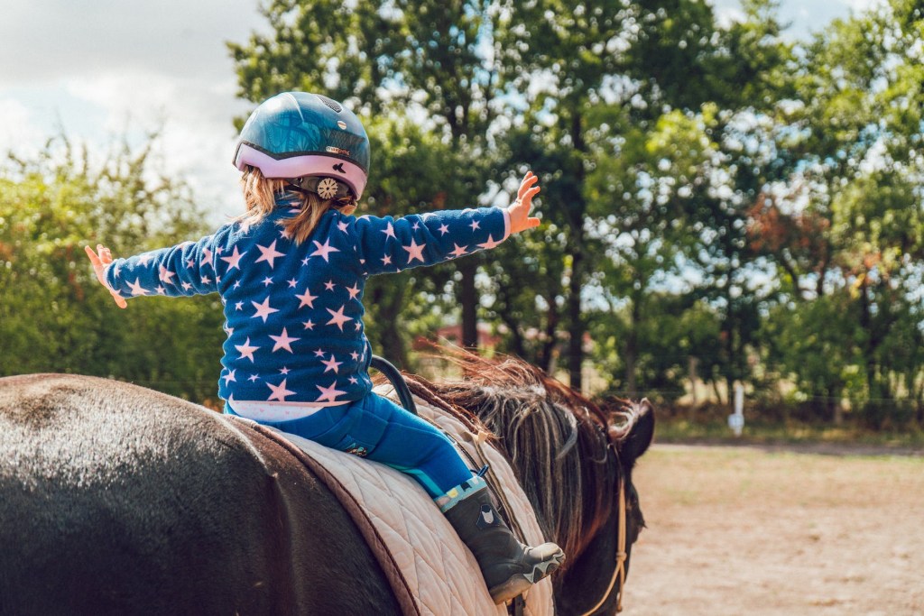 child on horse with helmet