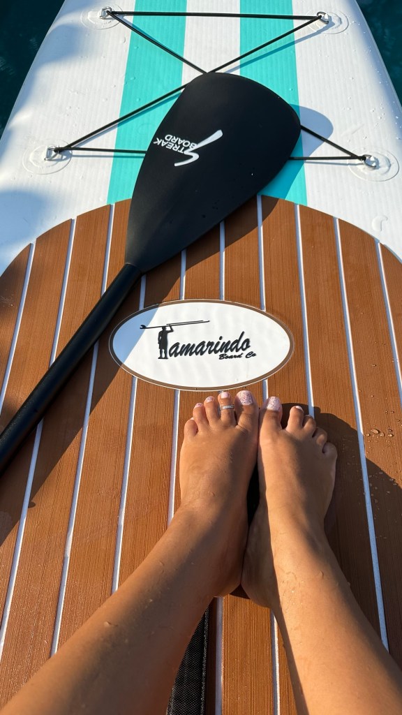 feet relaxing on a paddle board with paddle