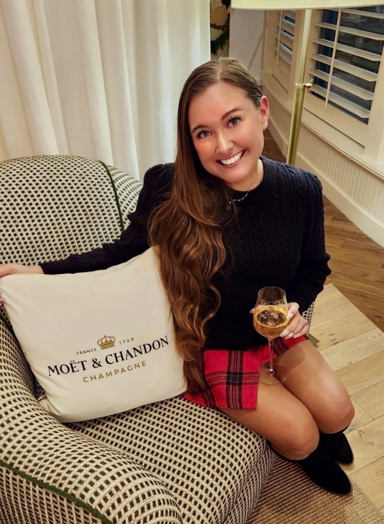 the Virginia hype girl hold a glass of Moet and Chandon champagne at the view room at the Moet lounge inside of the view room at the Tides Inn